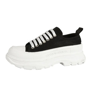 Black canvas lace-up sneakers with white laces and a chunky platform sole.