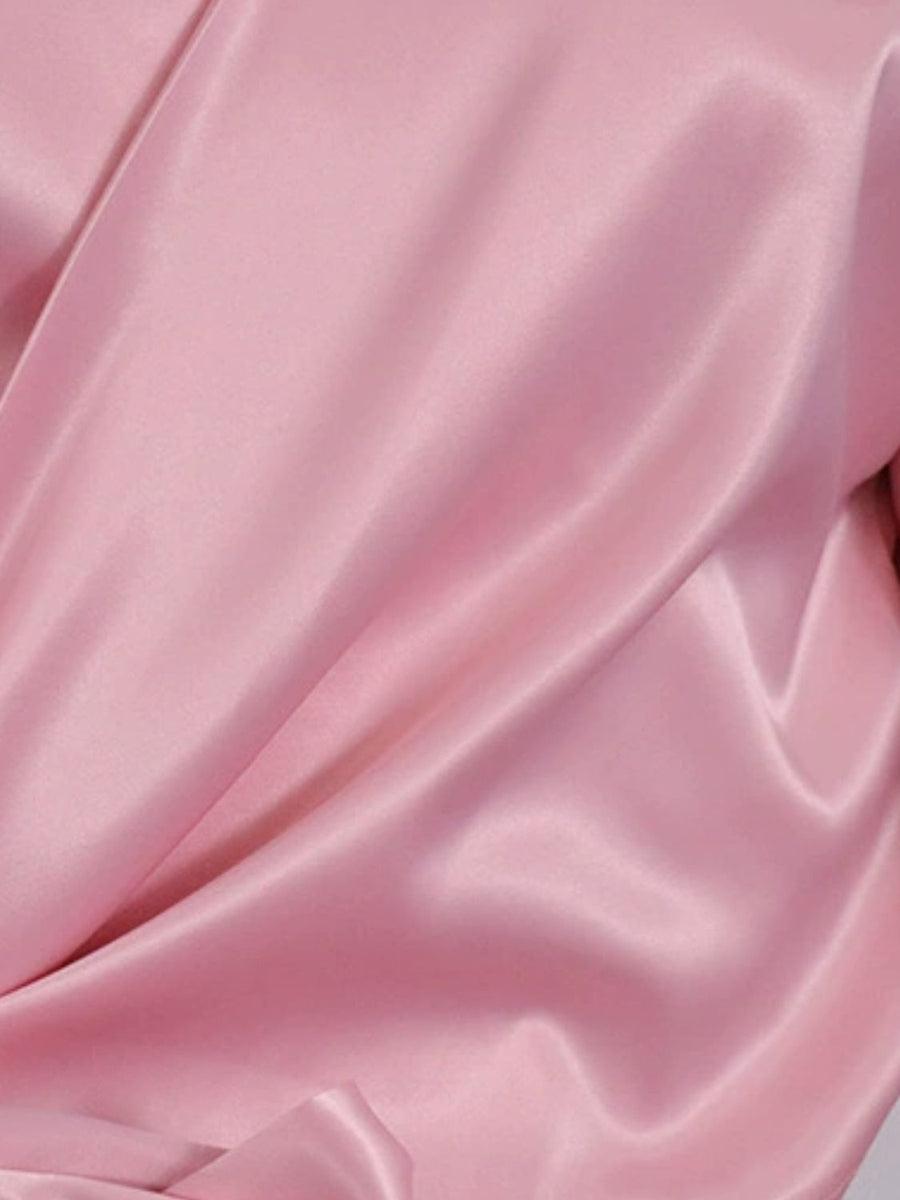 Blush pink satin blouse with draped detail and brooch.