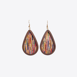 Cork and stripe teardrop statement earrings with wooden frame and colorful vertical lines.