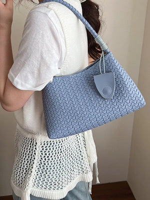 Blue woven shoulder bag with braided strap and leather tab detail