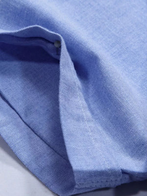 Men's sky blue cotton button-down shirt detail showing pocket and button.