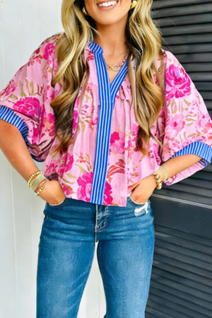 Pink floral v-neck blouse with blue striped accent and short sleeves