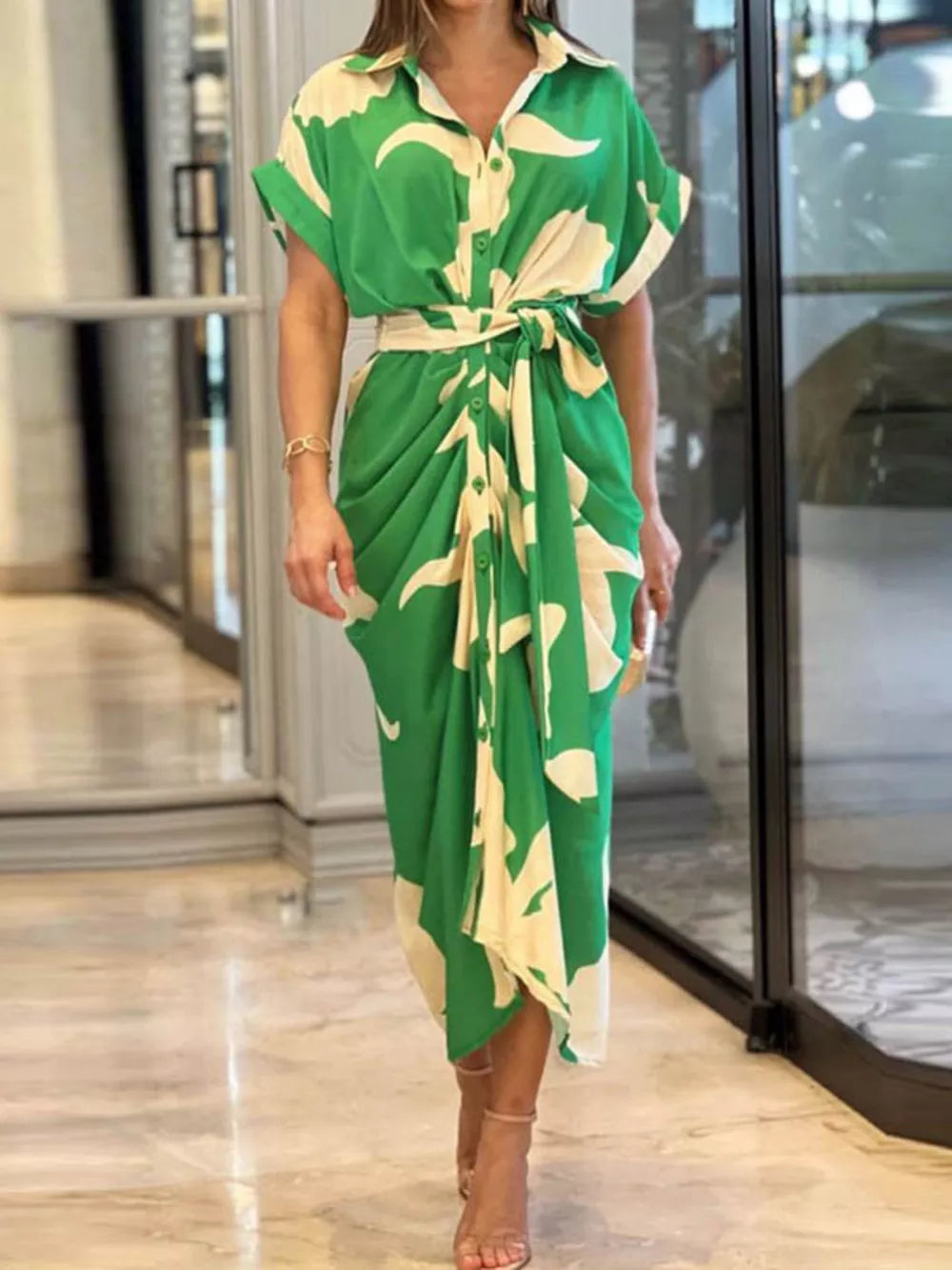 Green abstract print belted shirt dress with short sleeves and collared neckline.