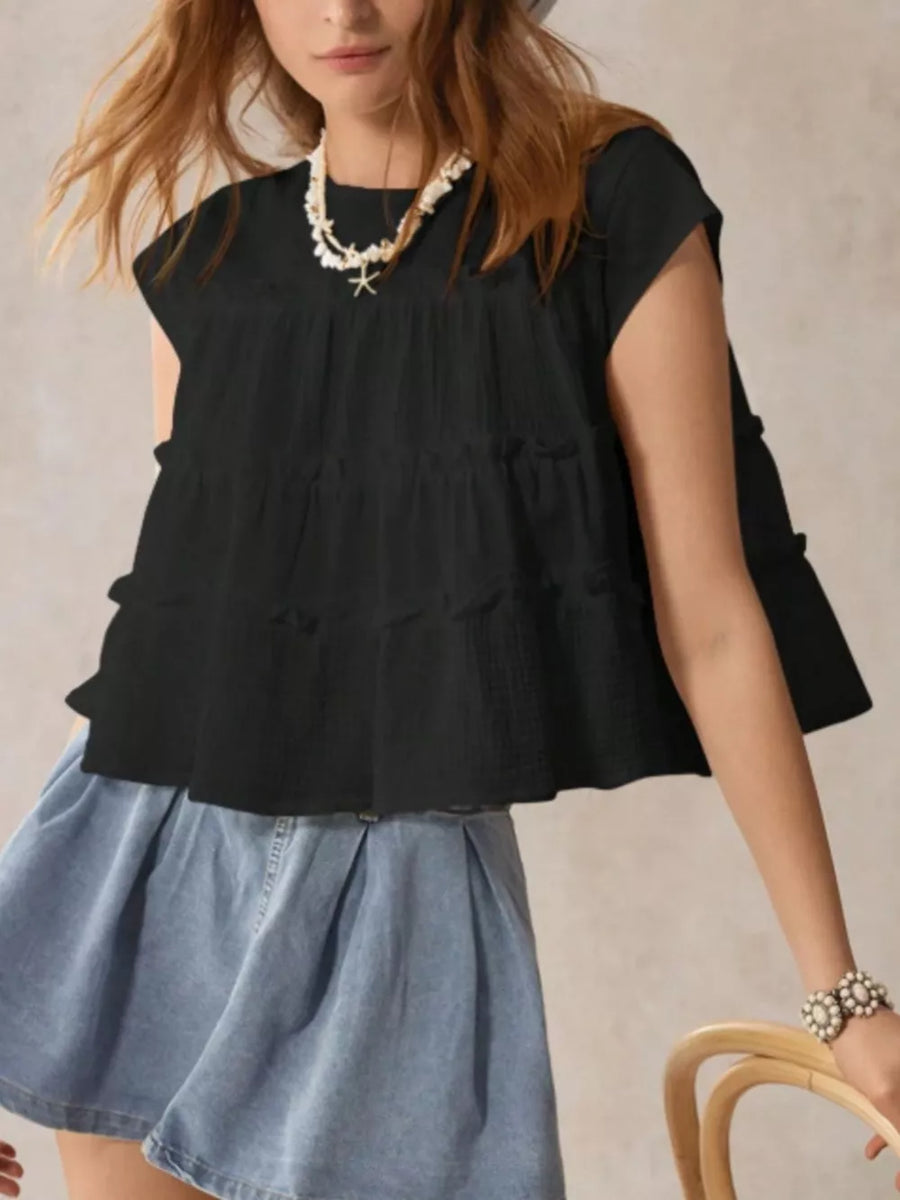 Black tiered ruffle blouse with short sleeves and textured fabric.