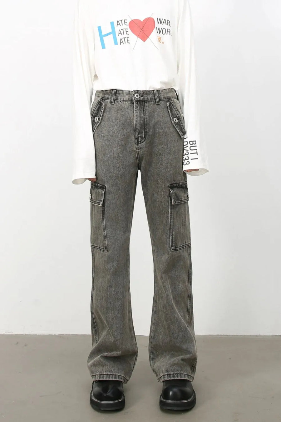 Faded dark gray denim flare cargo pants with multiple pockets and a relaxed fit.