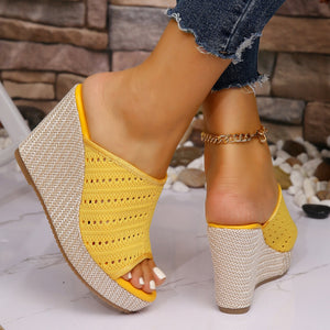 Yellow perforated espadrille wedge sandals with woven wedge detail.