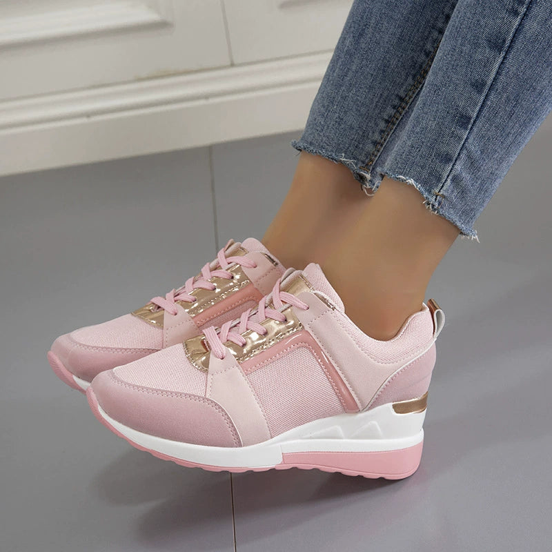 Pink lace-up wedge sneakers with metallic accents and white soles.