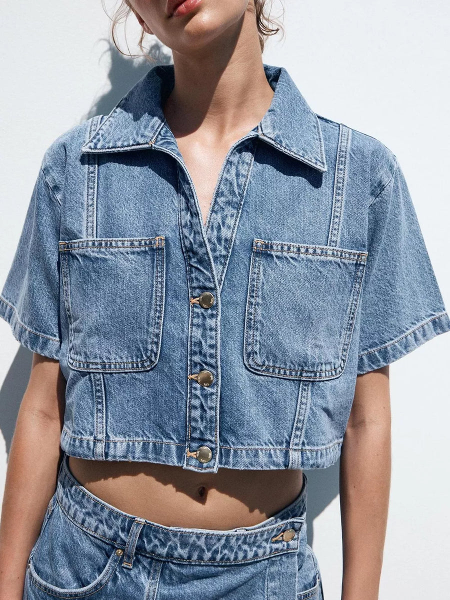 Dark blue cotton cropped button-up top with chest pockets and contrast stitching.
