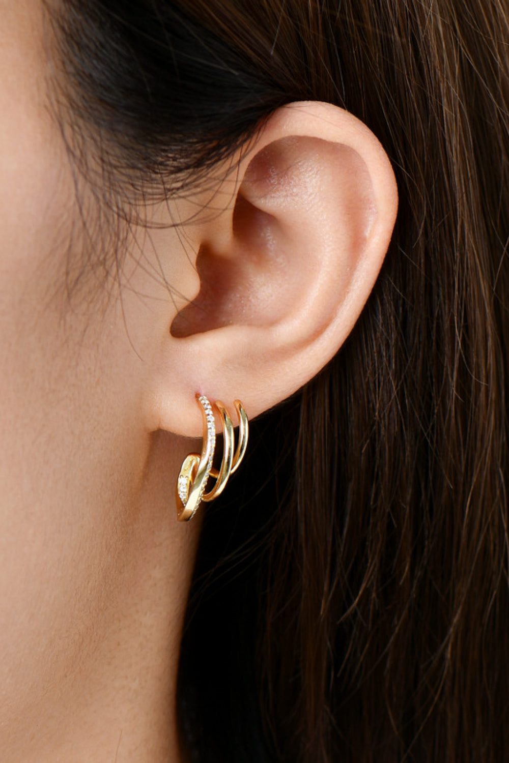 Gold triple hoop diamond stud earrings with a curved design.