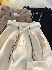 Cream drawstring hoodie with embossed text and contrast drawstrings.