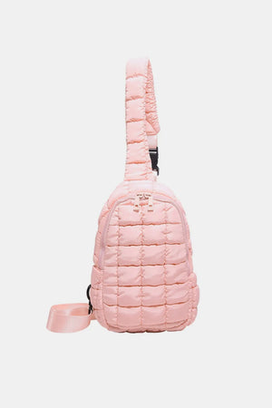 Padded sling bag in blush pink with quilted texture and adjustable strap.