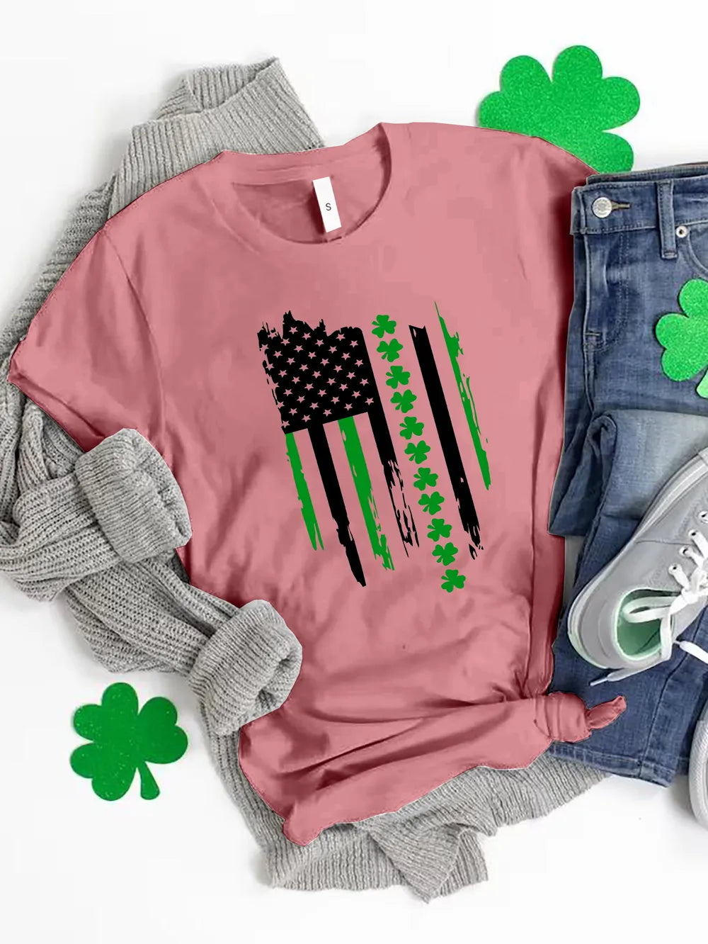 Pink t-shirt with distressed American flag graphic featuring shamrocks and green stripes.