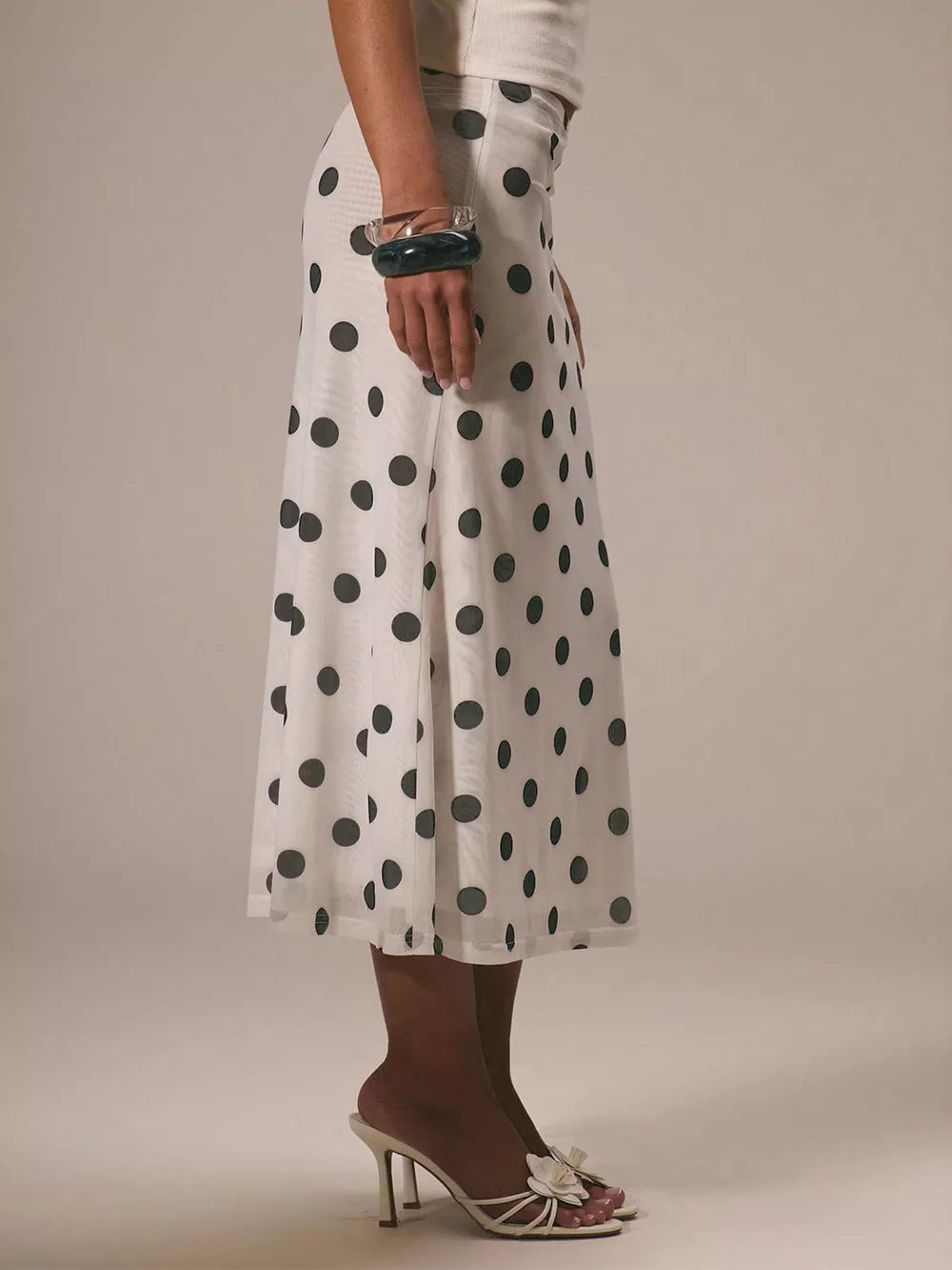 Classic polka dot midi skirt in white with black dots, featuring a sheer hem.