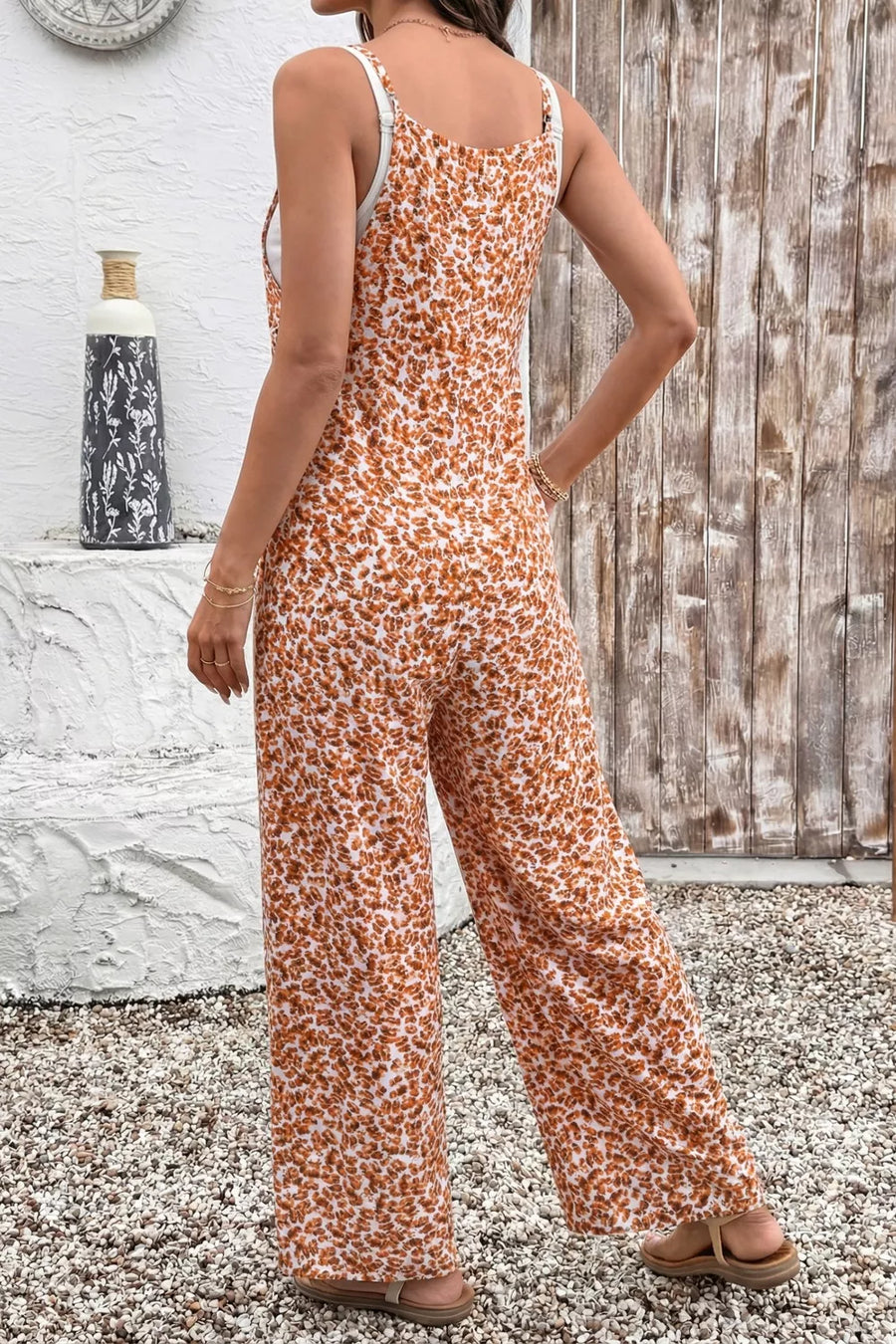 Abstract floral wide-leg romper with adjustable straps and white lining.