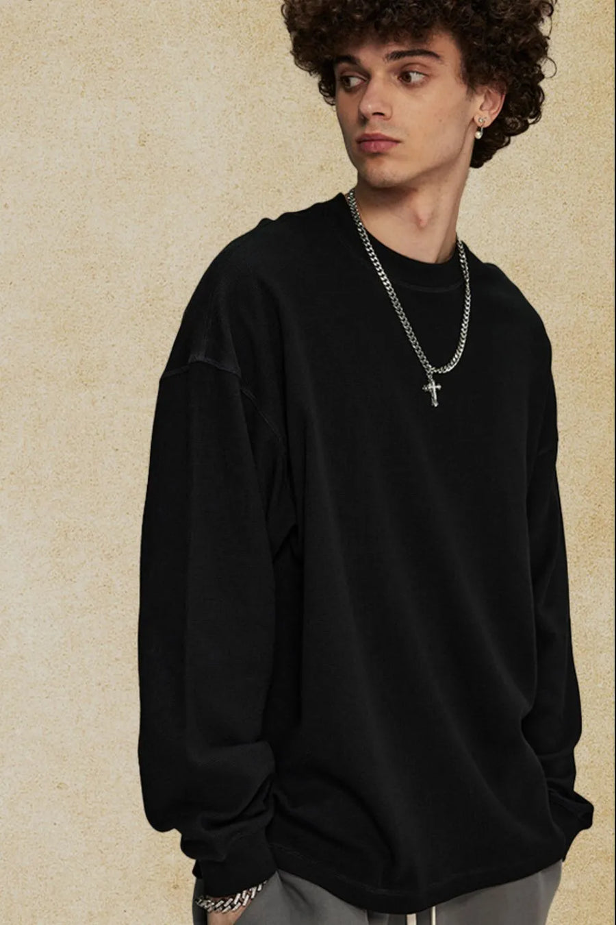 Black oversized drop shoulder crewneck sweatshirt with crew neckline and long sleeves.