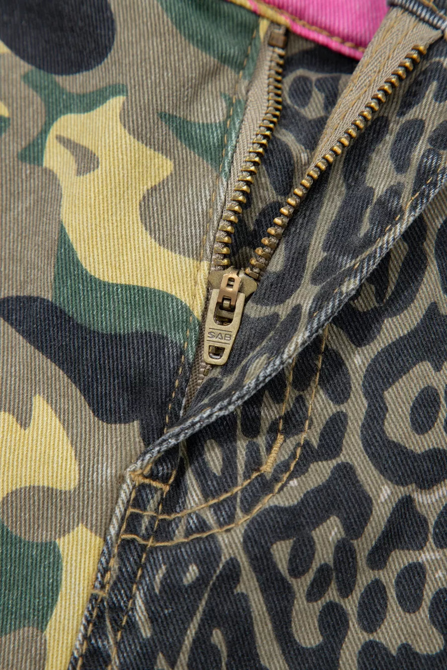 Contrast patchwork jeans with camo and leopard print, featuring a zip fly and contrast stitching.