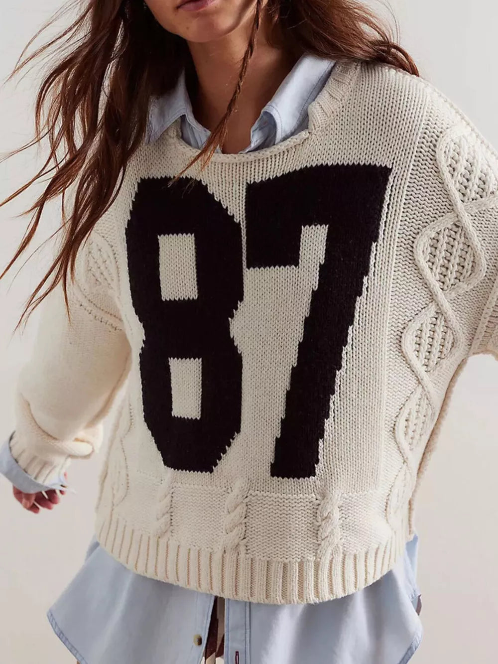 black pullover sweater featuring cable-knit and graphic print