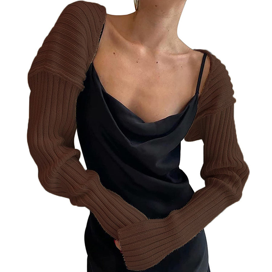 Brown ribbed knit shrug with extended sleeves worn over a black slip dress