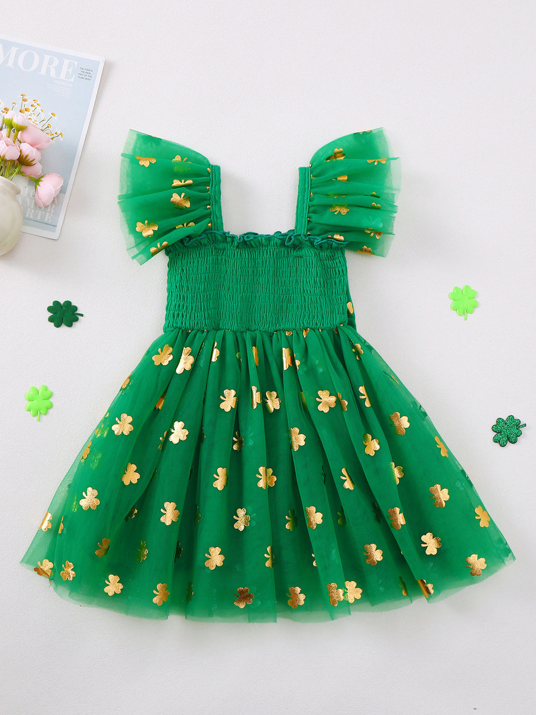 Green tulle baby dress with gold shamrock print, smocked bodice, and flutter sleeves.