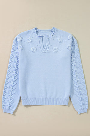 Light blue sweater with floral embellishments and cable knit sleeves
