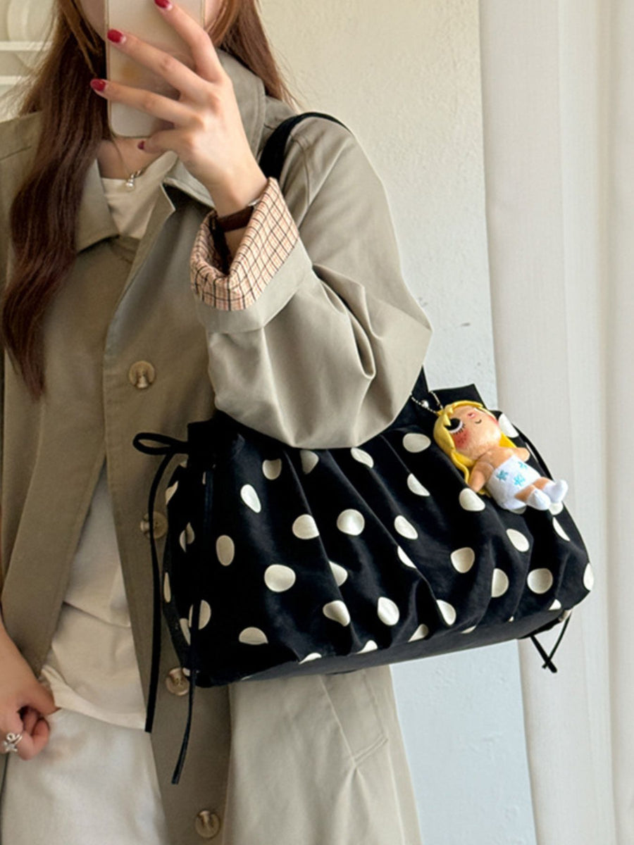 white shoulder bag featuring drawstring sides and polka dot