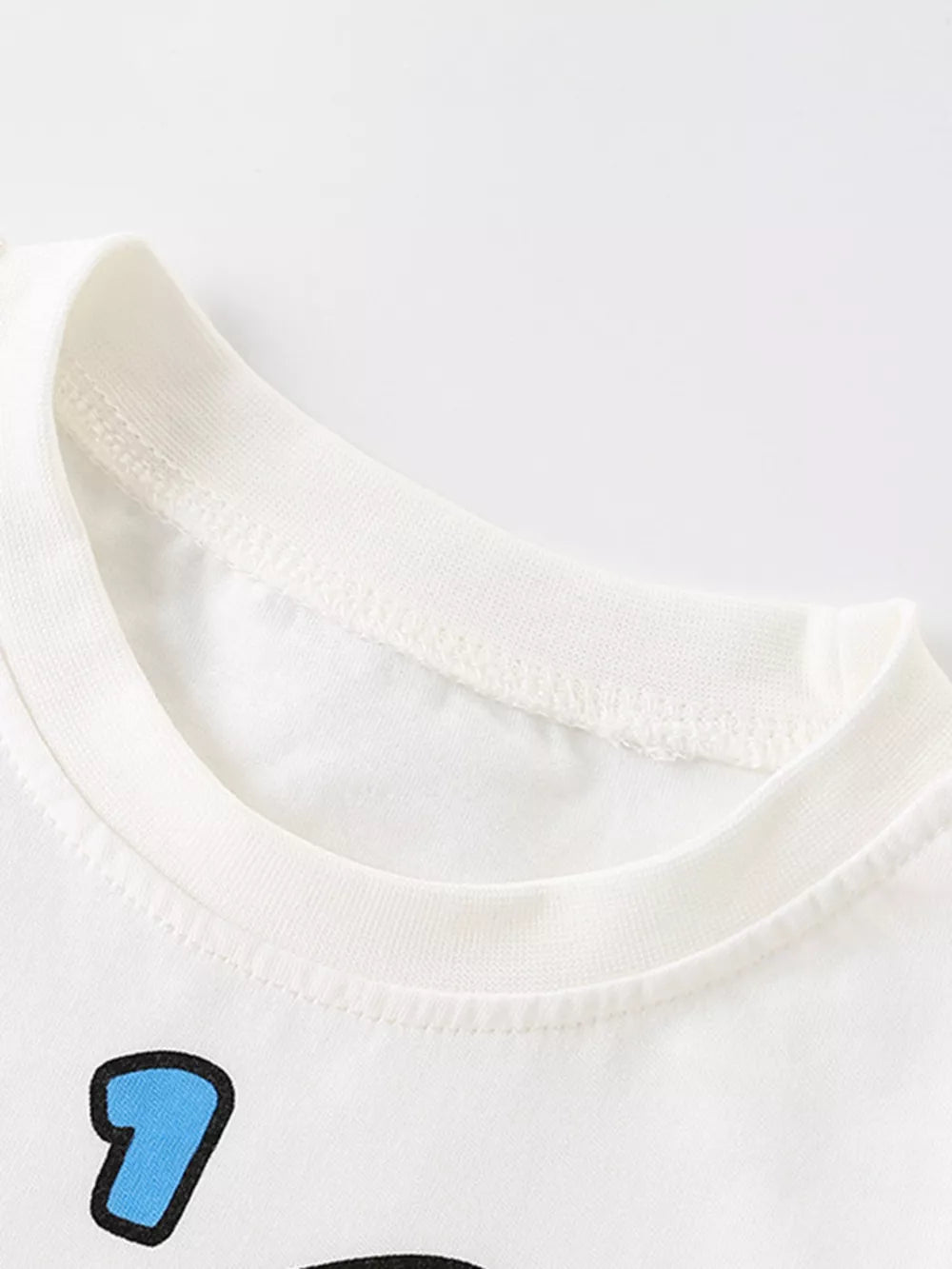 White cotton crew neck t-shirt with blue cartoon rocket graphic detail.