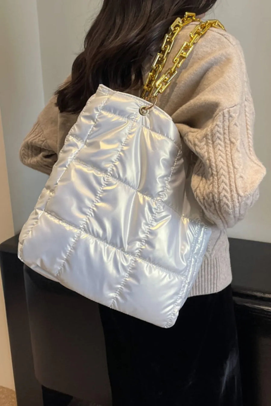 White quilted nylon tote bag with shiny finish and gold chain handle.