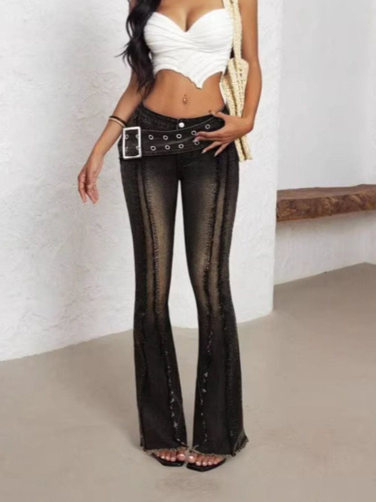 Belted high waist flare jeans in dark wash denim with distressed seams and frayed hem.