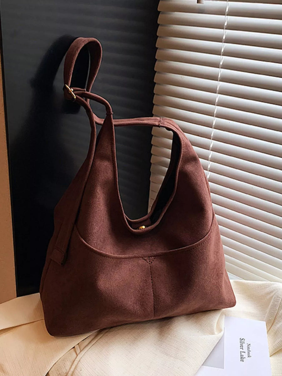 Large chocolate suede shoulder bag with a single strap and gold hardware
