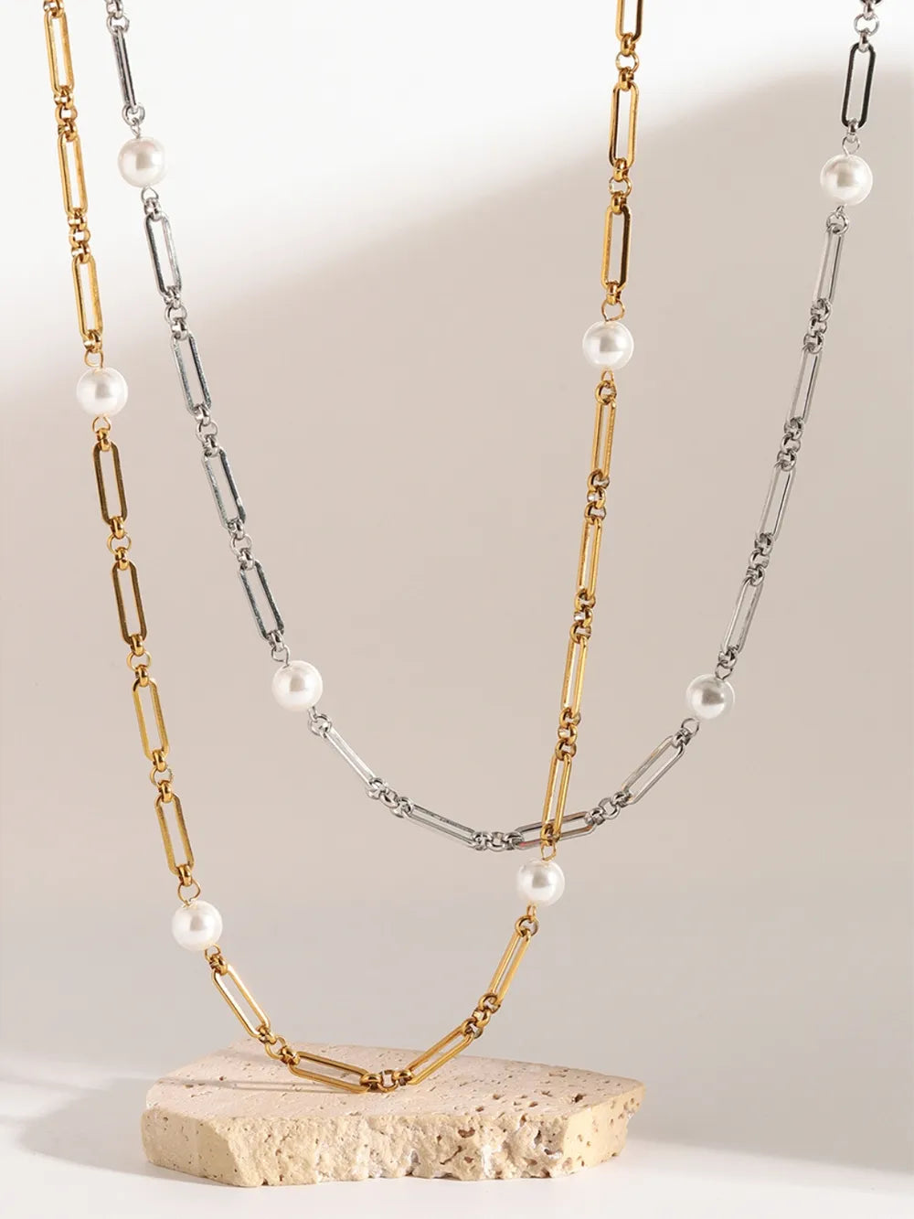 Two-tone pearl link necklace in gold and silver with alternating chain links and pearls.