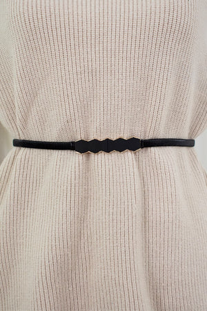 Black geometric buckle waist belt with gold trim, styled on a cream sweater.