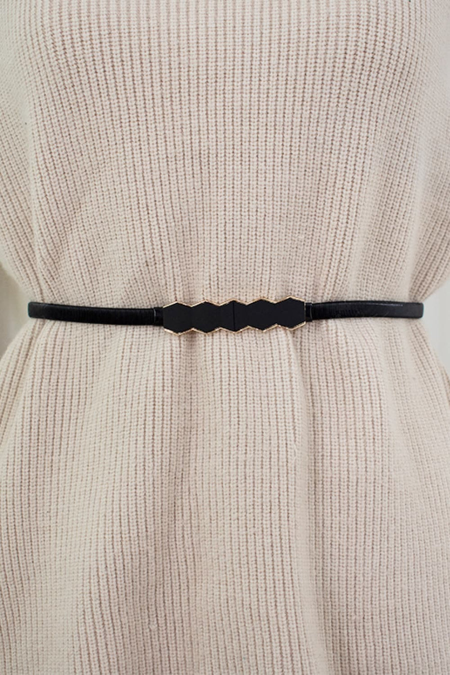 Black geometric buckle waist belt with gold trim, styled on a cream sweater.