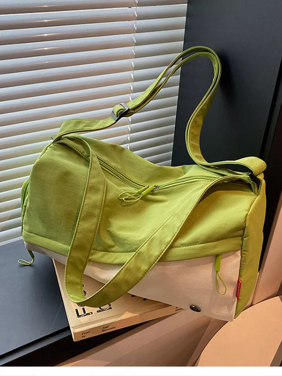 Vibrant color-block nylon travel bag with adjustable strap and zippered compartments.