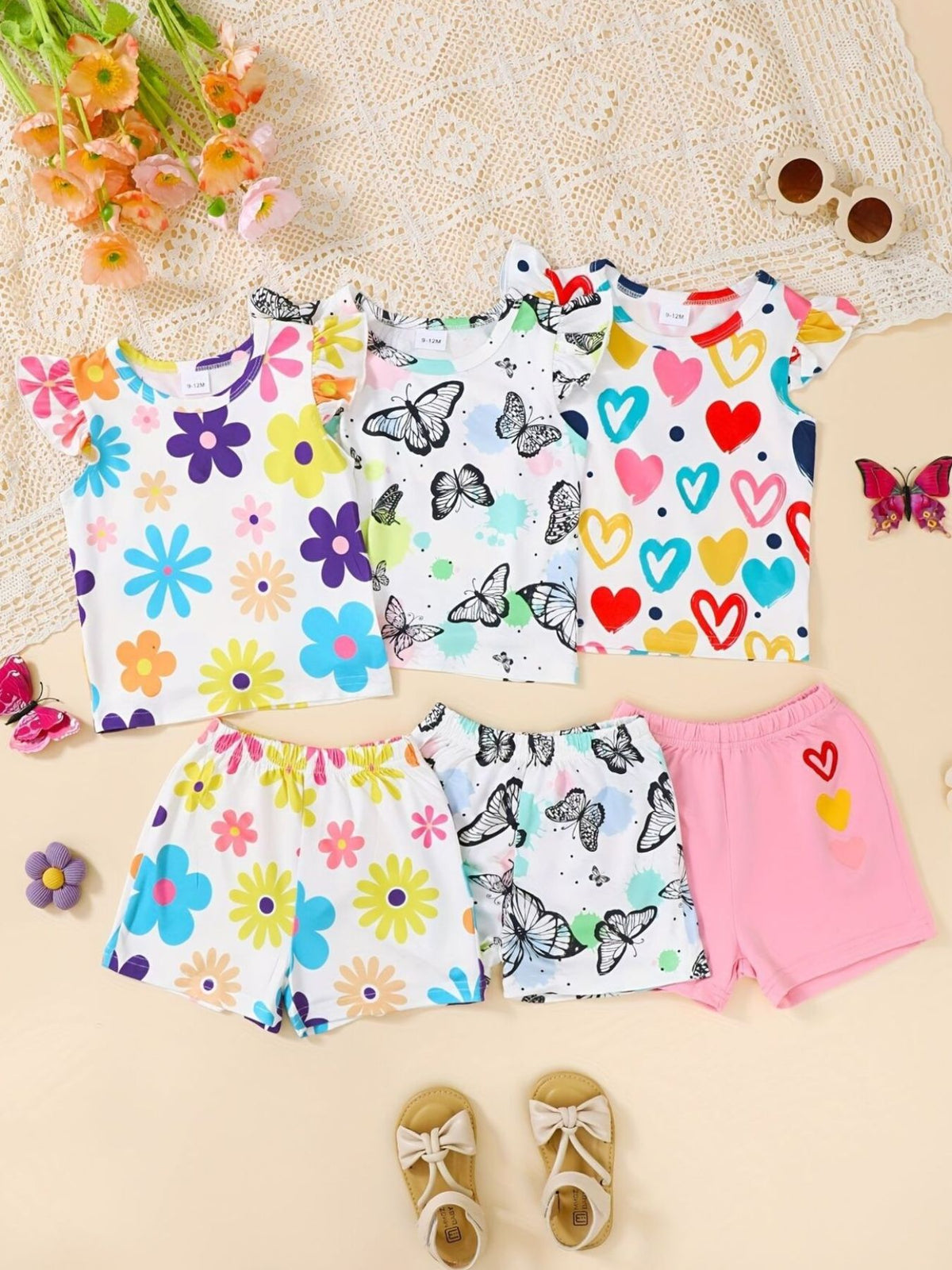 Baby sets with butterfly and heart prints, floral patterns, flutter sleeves, and shorts.