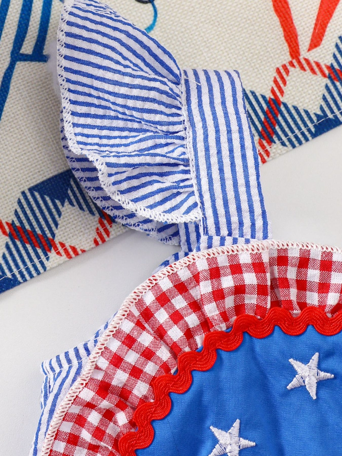 Patriotic baby dress with blue stripes, red gingham, and white stars.