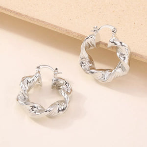 Textured silver hoop earrings with a twisted design.