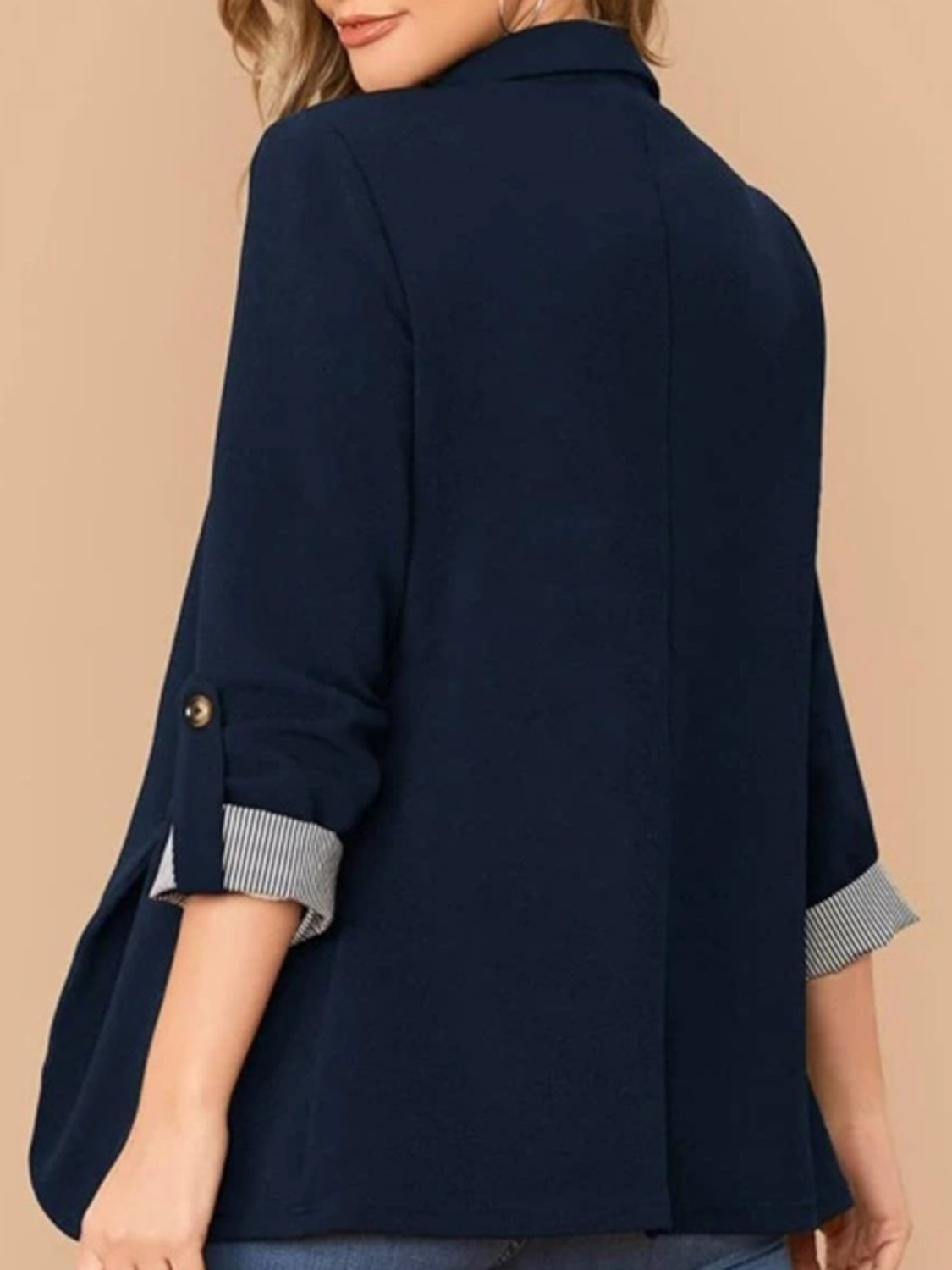 Dark blue blazer with cuffed sleeves featuring striped lining and button detail