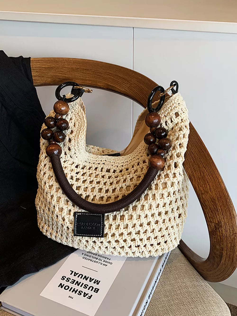 Khaki crochet tote bag with beaded handles and dark brown trim.