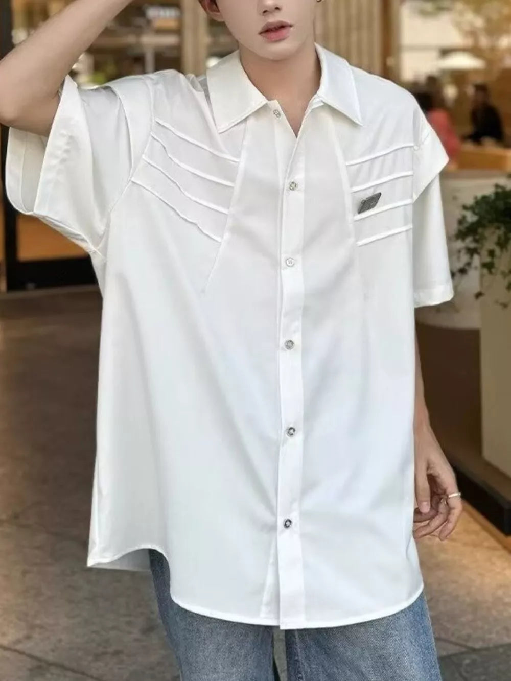 White relaxed fit oversized button-up shirt with chest pleats and short sleeves.