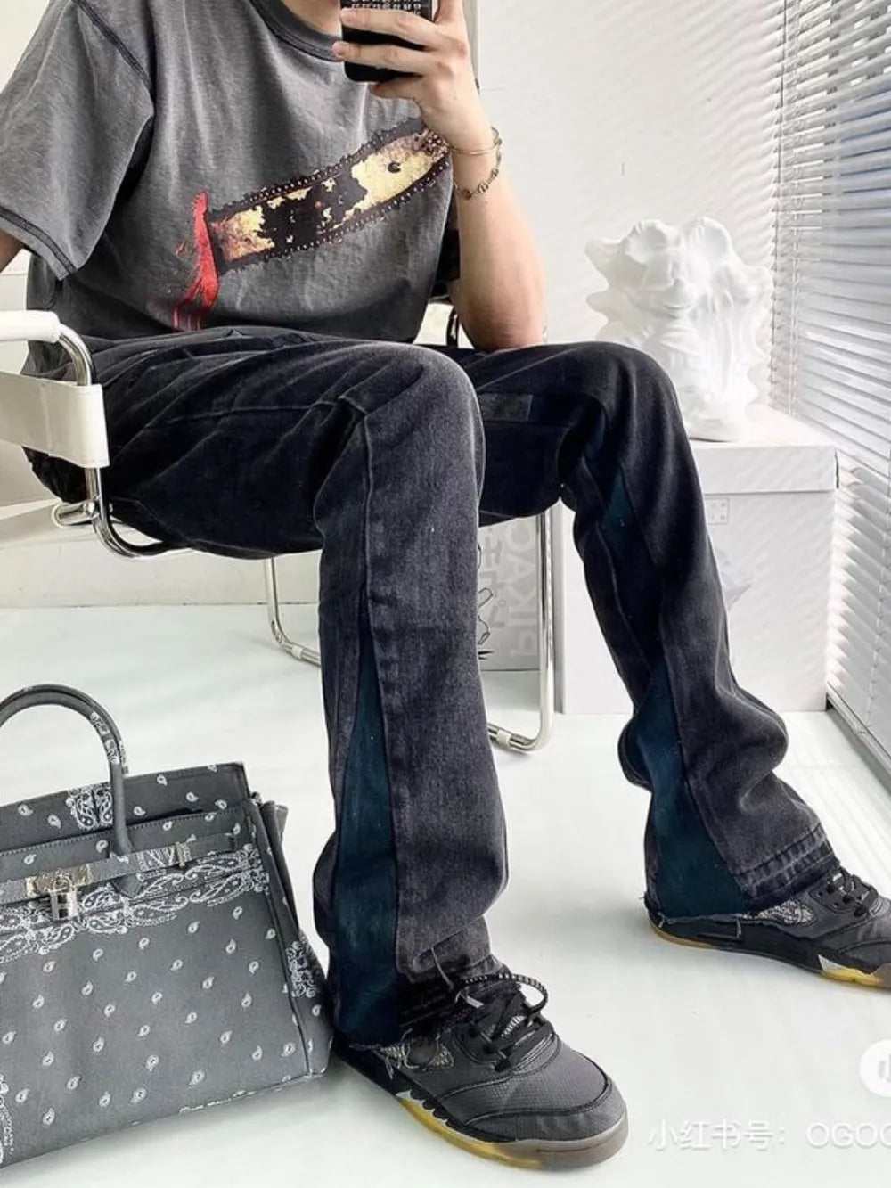 Dark two-tone denim bootcut jeans with raw hem and contrast side panels.