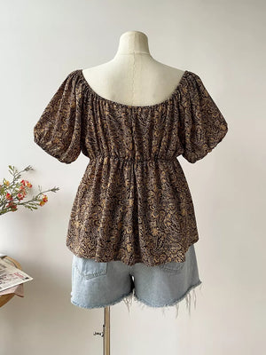 Plus size coffee brown paisley print drapey blouse with smocked waist and puff sleeves.