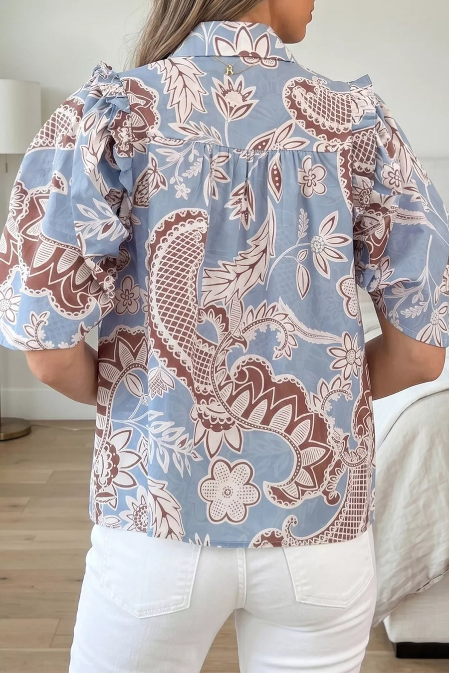 Blue cotton button-up shirt with floral pattern and ruffled sleeves.
