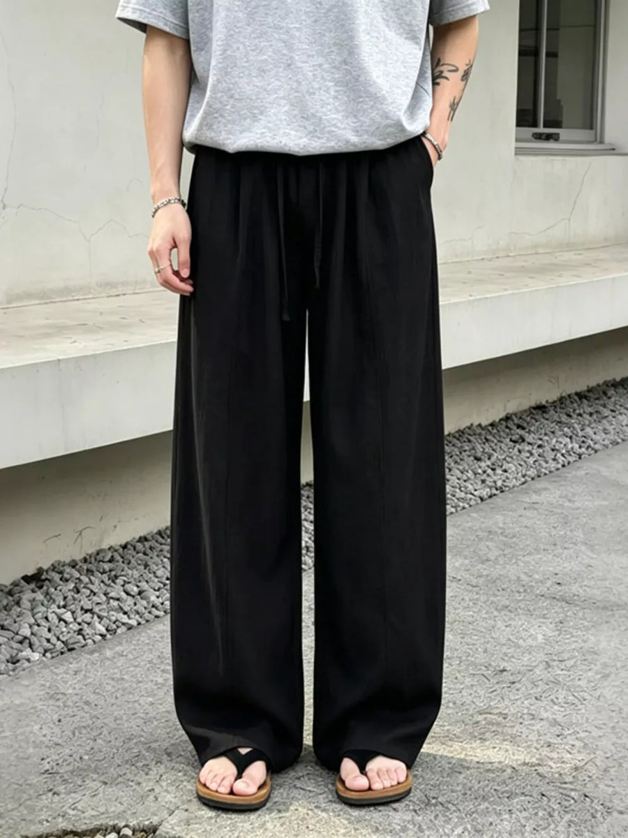 Black wide-leg sweatpants with drawstring and front seam detail.