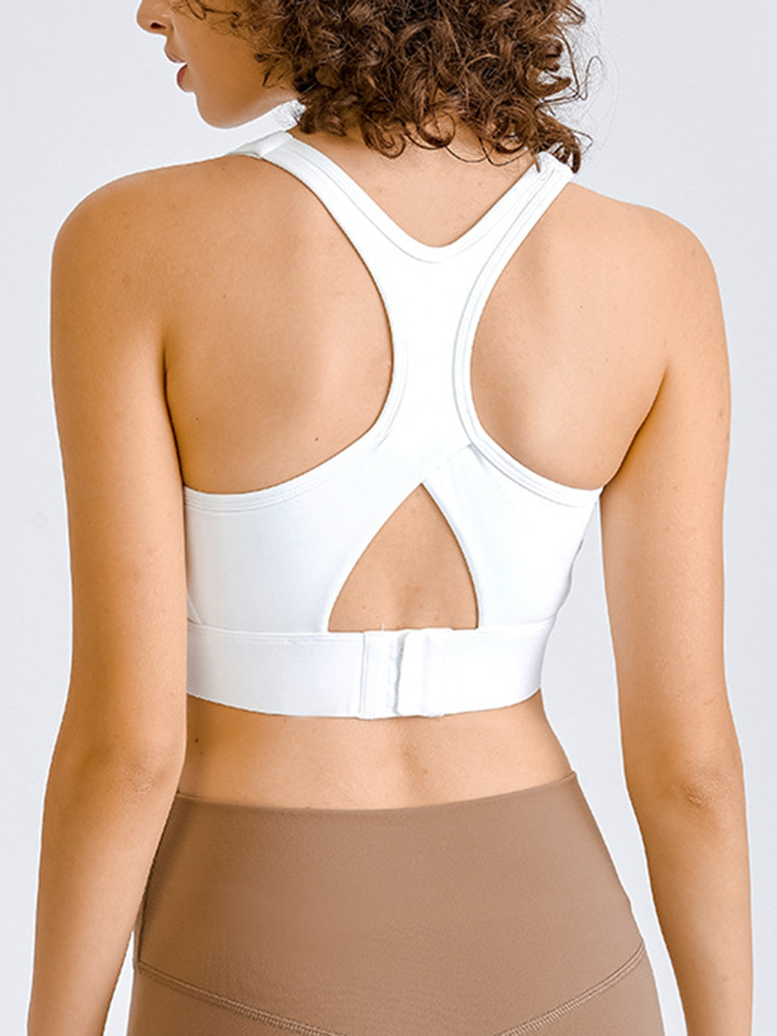 White sculpted racerback crop top with cutout detail and hook-and-eye closure.