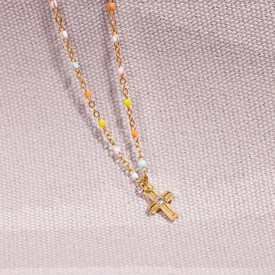 Gold bead necklace with rainbow beads and a crystal cross pendant.