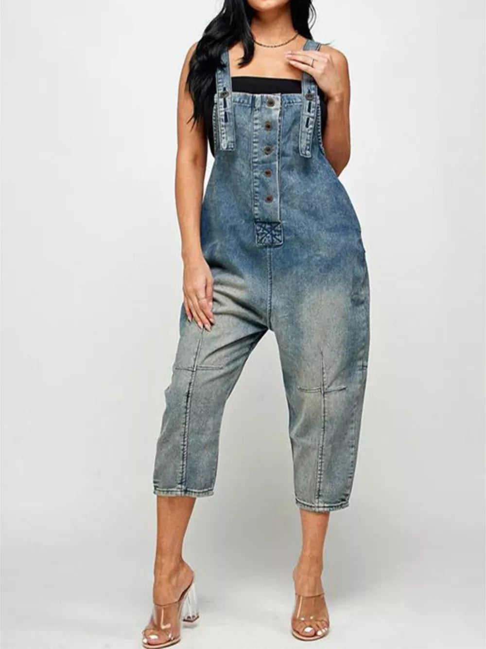 Denim overalls with button front and adjustable straps in a light blue wash.