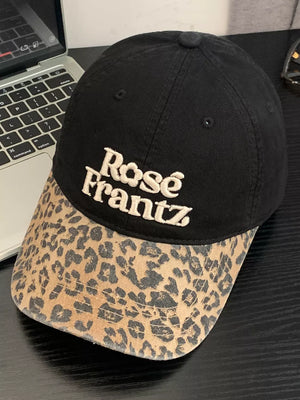 Black cotton baseball cap with leopard print brim and embroidered text.
