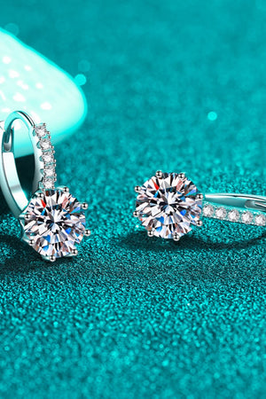Sterling silver moissanite halo hoop earrings with sparkling round-cut center stones.