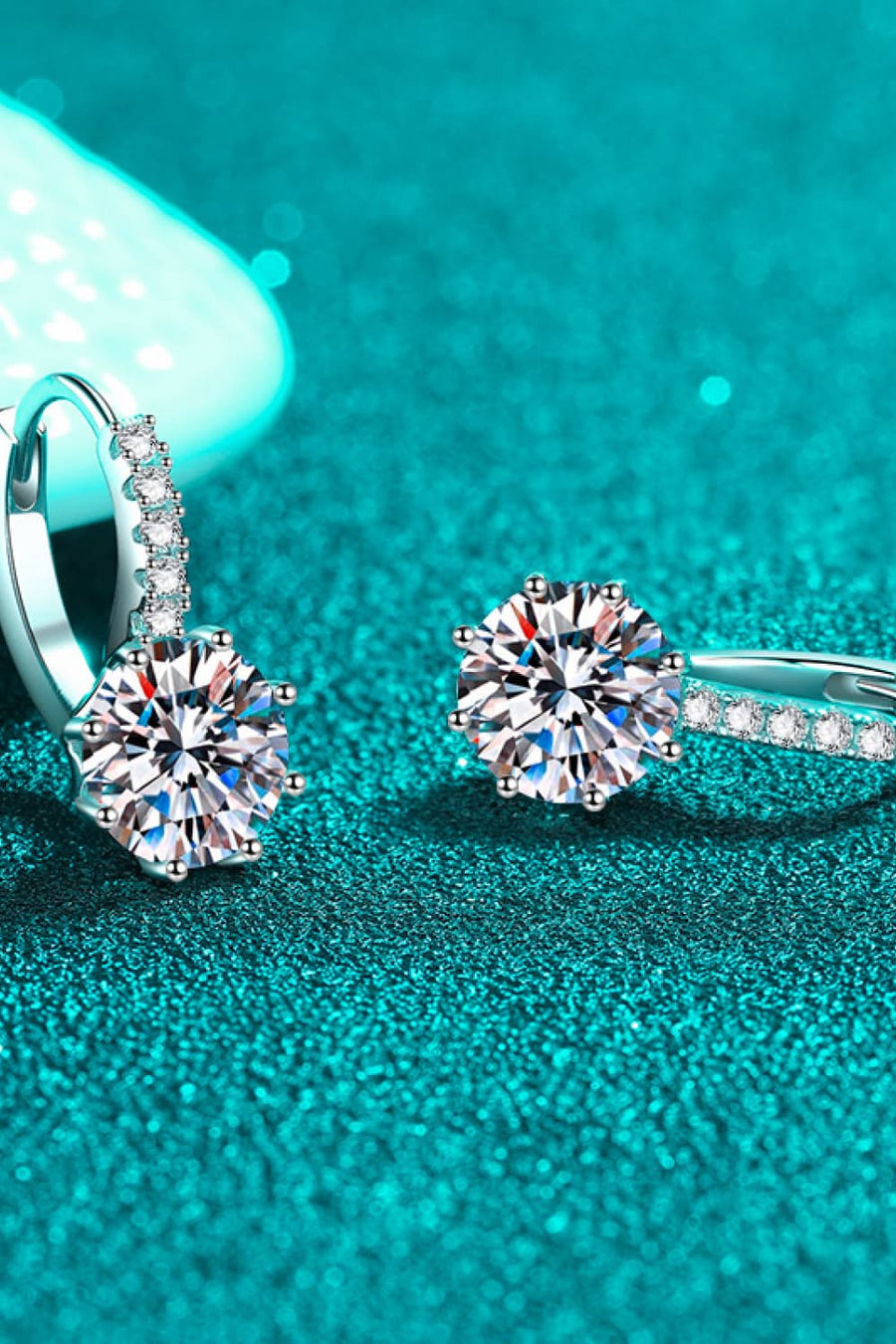 Sterling silver moissanite halo hoop earrings with sparkling round-cut center stones.