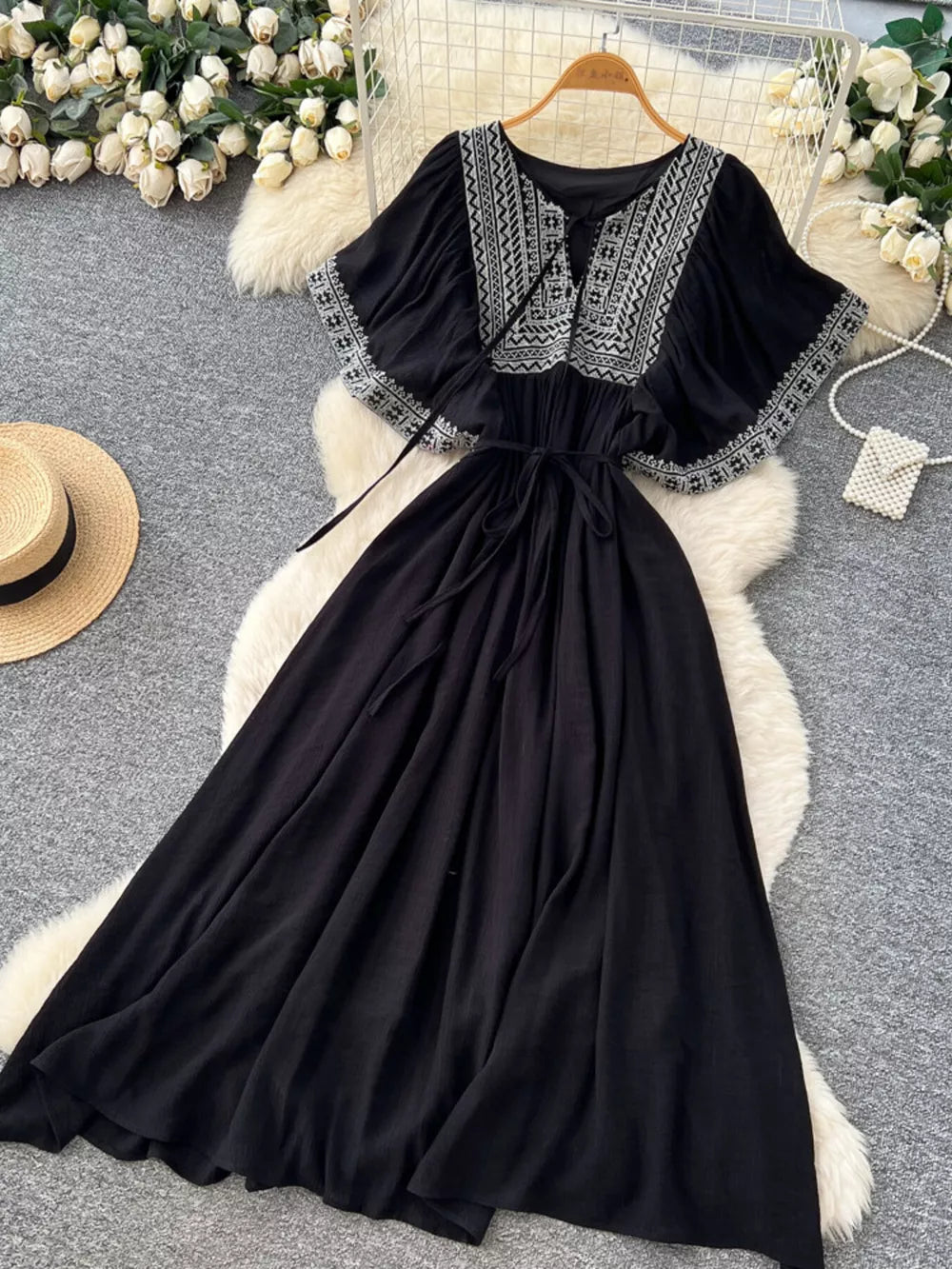 Black embroidered V-neck bohemian maxi dress with flutter sleeves and tie waist.